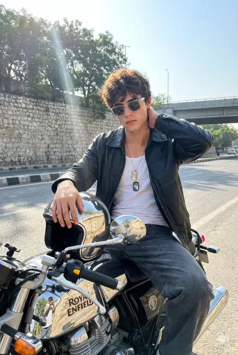A tough boy on a Royal Enfield motorcycle bathed in the morning sun