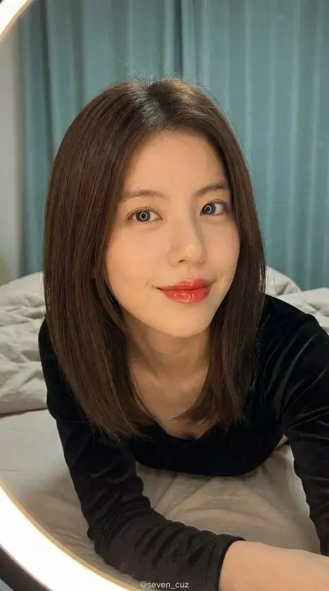 Beautiful girl taking selfie under ring light in lazy bedroom