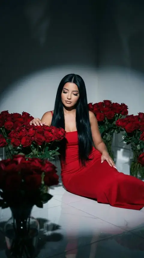 Beauty in dark red dress in a sea of ​​roses