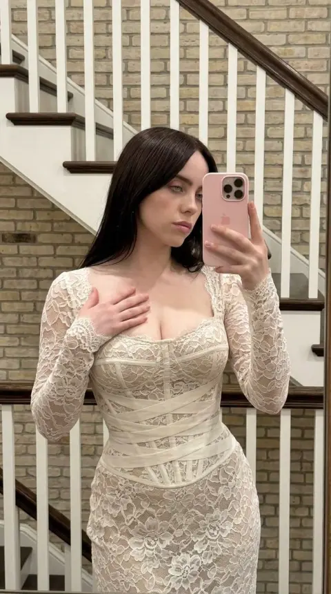 Billie takes a beautiful selfie in front of the mirror in lace dress