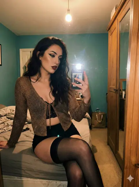 Charming mirror selfie in a dark bedroom wearing a see-through gold shirt