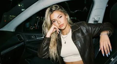 Cool blonde girl under the flashlight in the car at night