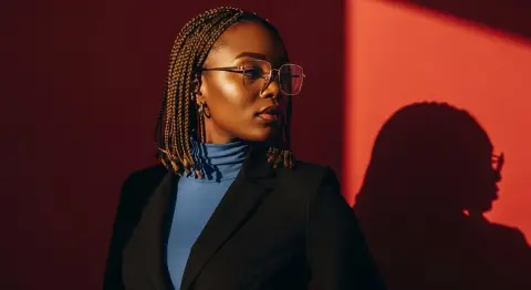 Elegant African American girl under the light and shadow of the red wall