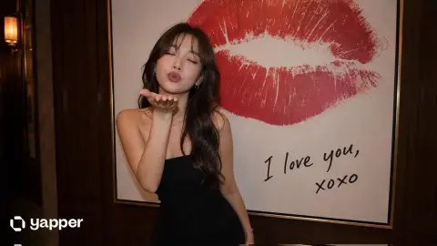 Elegant East Asian woman playfully blowing kiss in front of modern art painting