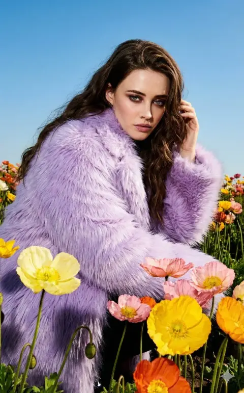 Fashion shoot of purple fur in flower fields under direct sunlight