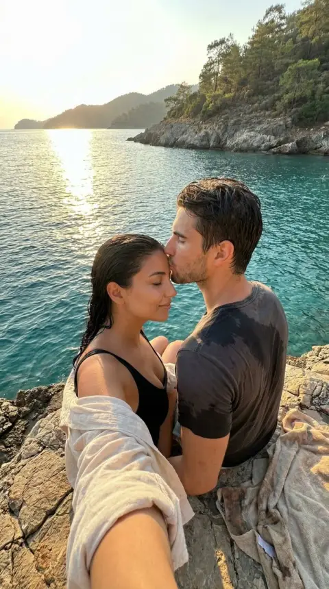 Gentle forehead kiss on the sea rock at dusk