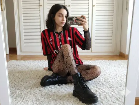 Hot girl in red and black striped jersey takes carpet mirror selfie