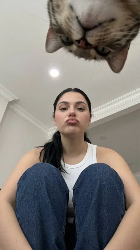 Low angle shot of a cowboy girl hugging her knees from above
