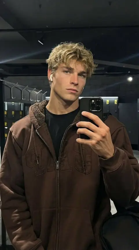 Man with cool blond hair in front of mirror in gym