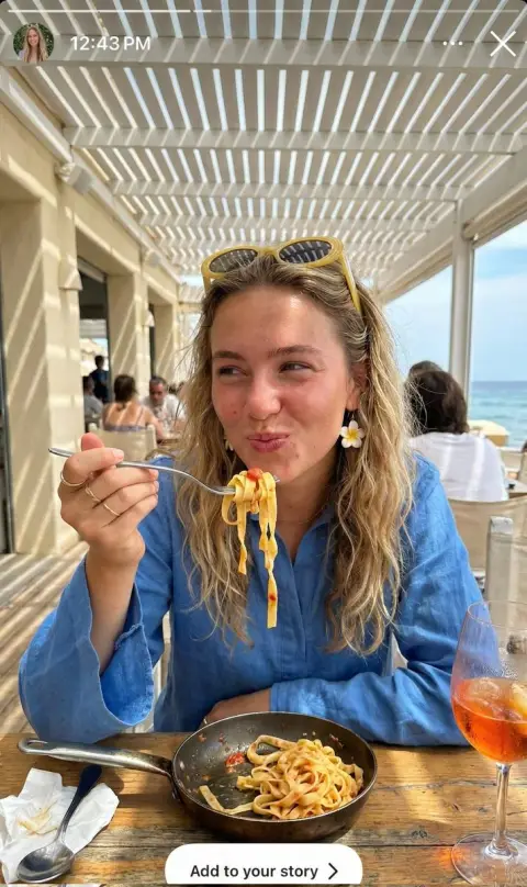 Mediterranean vacation girl rolling up pasta under dappled sunlight