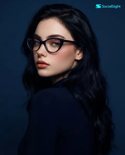 Photography of girl in glasses looking back confidently sideways on blue background