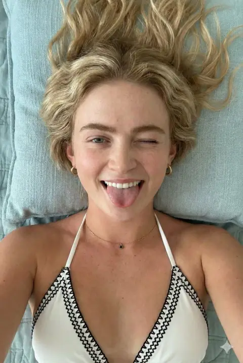 Playful grimace of blond girl with freckles in the sun