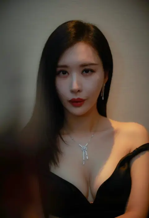 Portrait of elegant woman with red lips and black dress under dramatic light and shadow