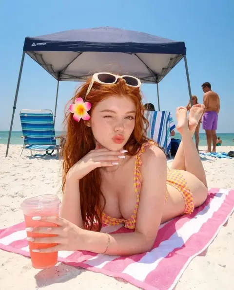Red-haired beauty in bikini on summer beach