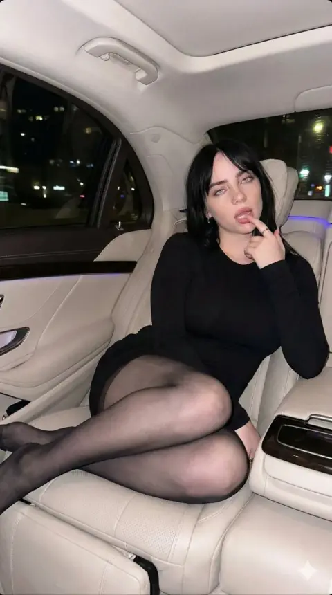 Red-haired seductive girl in the back seat of a luxury car