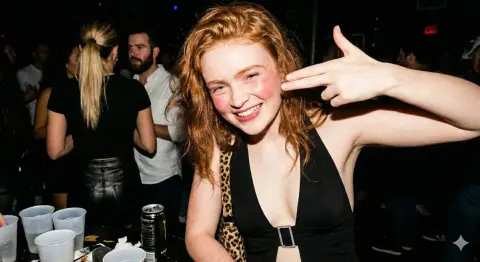 Redhead hottie in nightclub playful finger gun