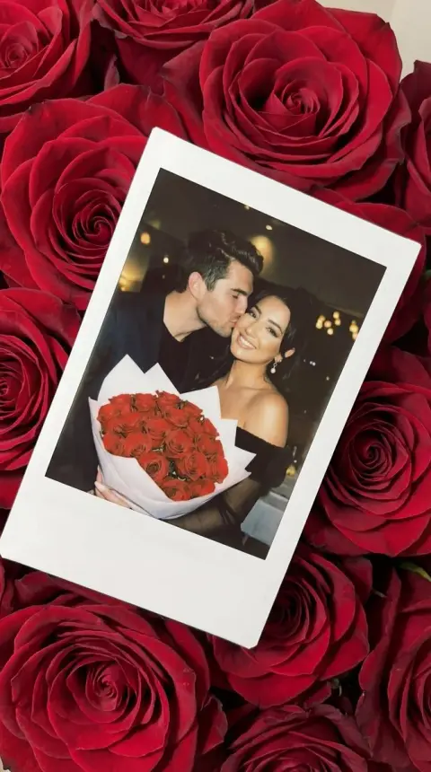 Romantic kiss polaroid scattered among red rose flowers