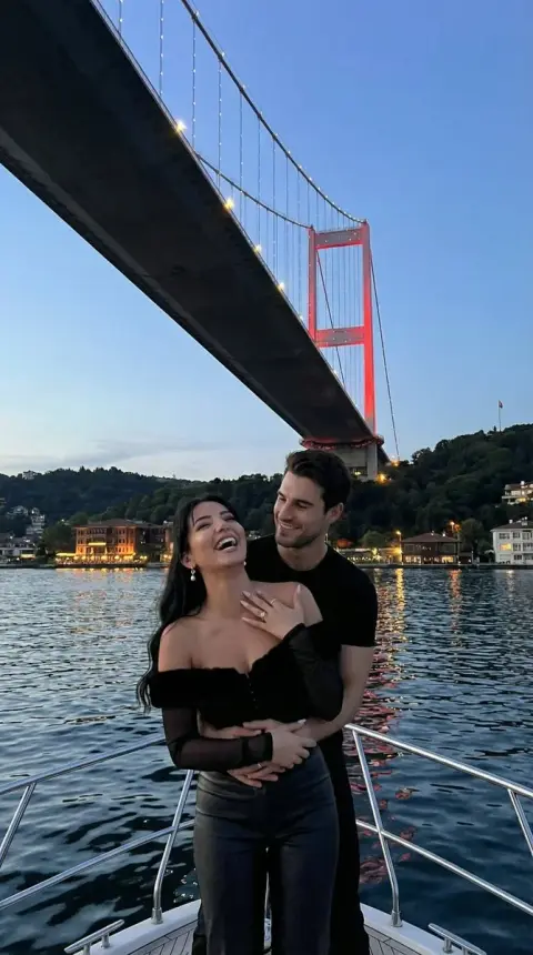 Romantic yacht hug moment under the Bosphorus Bridge