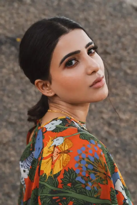 Soft light portrait of girl in crimson shirt with blooming flowers