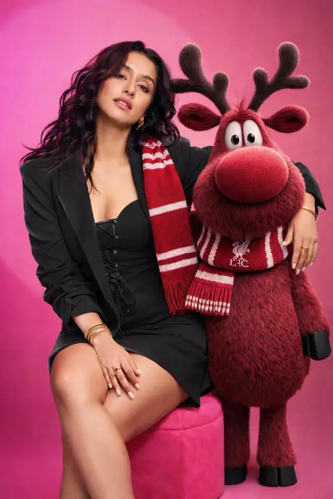 Studio portrait of woman in pink suit and anthropomorphic reindeer