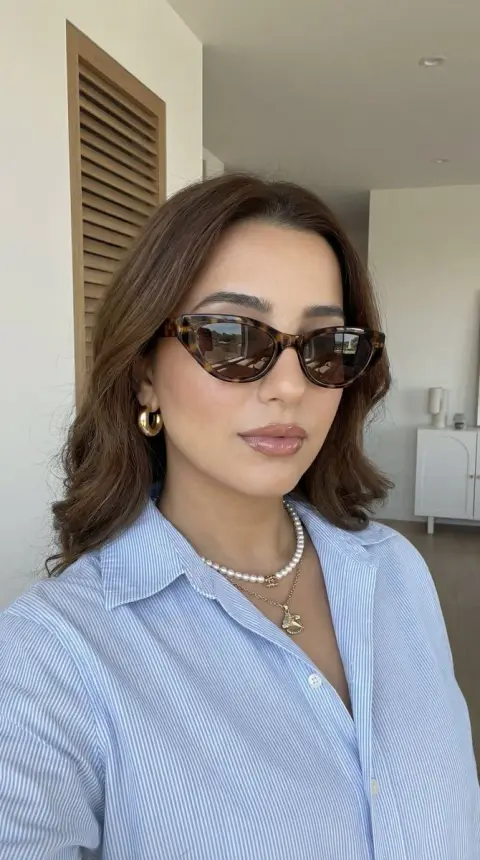 Textured selfie with tortoiseshell sunglasses and pearl necklace