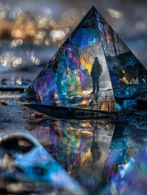 The wonder of balance on the tip of a glazed ceramic pyramid