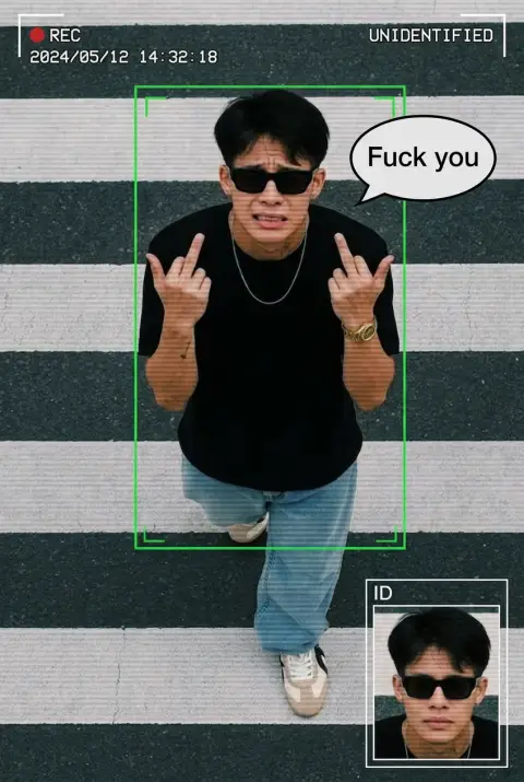 Use uploaded man as exact face reference, keep identity unchangedCCTV surveillance style, same ratio as image. Top-down street view with crosswalk, subject large in frame. 
Add "Fuck you" as a cartoonish stype text bubble to the right of the person
Add security UI overlay: green tracking box, “UNIDENTIFIED”, red REC dot, timestamp, ID panel with close-up.